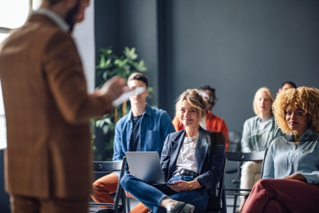 Audience members listen attentively to a presenter at a seminar.