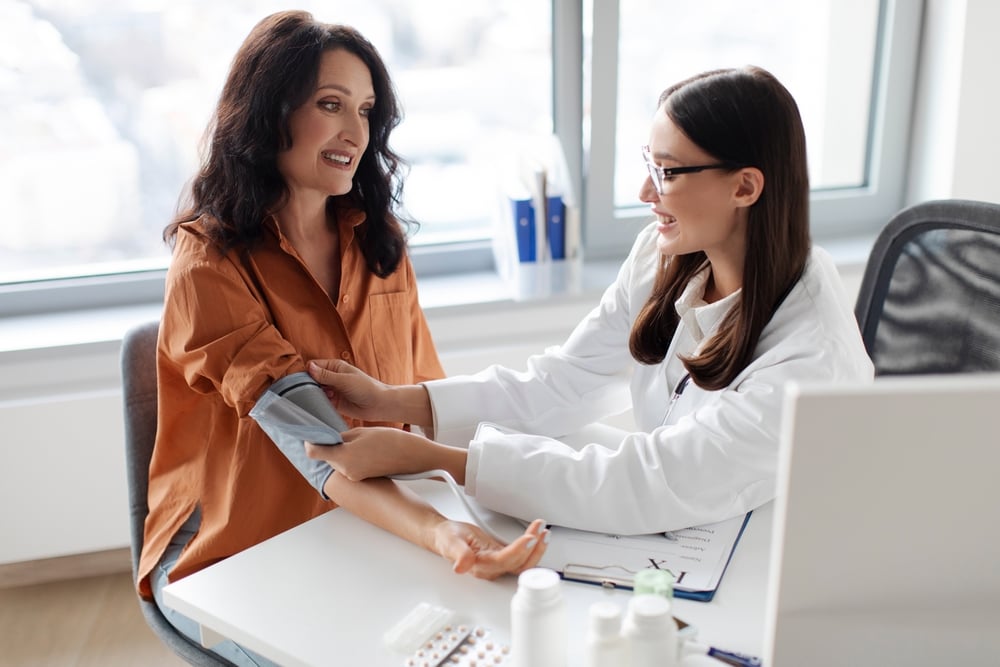 Clinician checking an adult patient's blood pressure during an ADHD titration review